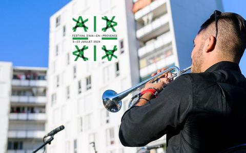 Visuel représentant un musicien de dos jouant de la trompette devant des immeubles