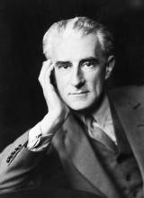 Photo noir et blanc de Maurice Ravel. Prise en plan rappoché, il soutient sa tête de sa main gauche.