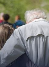 Photo de deux personnes de dos, une jeune et une personne âgée